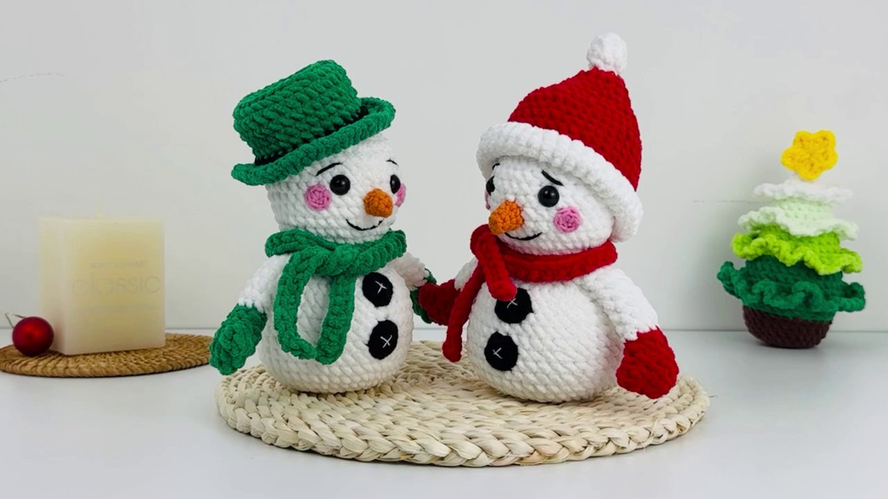 Craft a Festive Snowman Couple: A Cozy Crochet Tutorial for the Holidays 2 A close-up shot of hands holding red yarn and a gold crochet hook, beginning to form the snowman's arm.