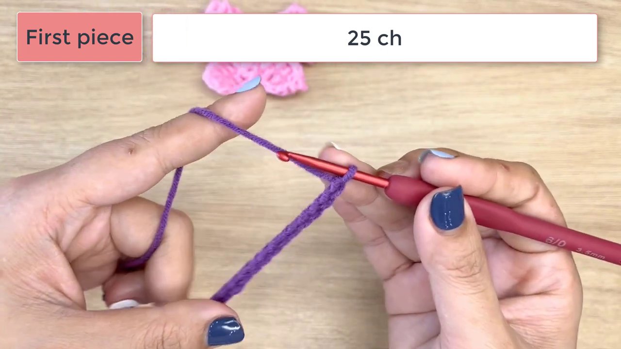 Master the Art of Crochet: A Step-by-Step Guide to Crafting a Beautiful Bow 4 The first purple piece is more developed, showing its distinct shape and texture against the light wood background.