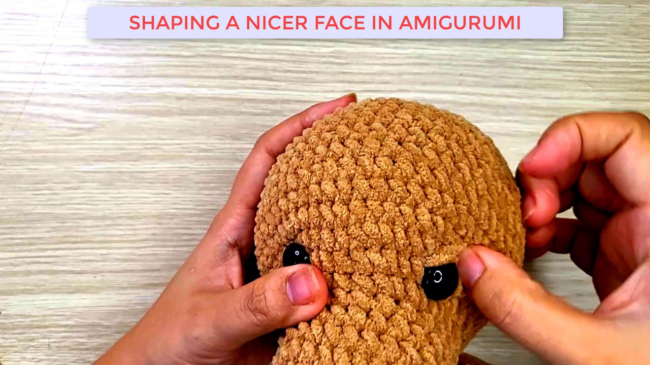 Mastering Amigurumi: A Step-by-Step Guide to Shaping and Embroidering a Dog's Face 4 A close-up view of the hands using the needle to sew and tighten specific areas, creating facial contours.