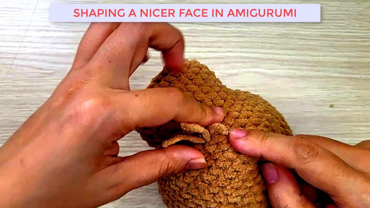 Mastering Amigurumi: A Step-by-Step Guide to Shaping and Embroidering a Dog's Face 6 One hand holds the dog head steady while the other hand pulls white yarn through to begin forming the eye highlight.