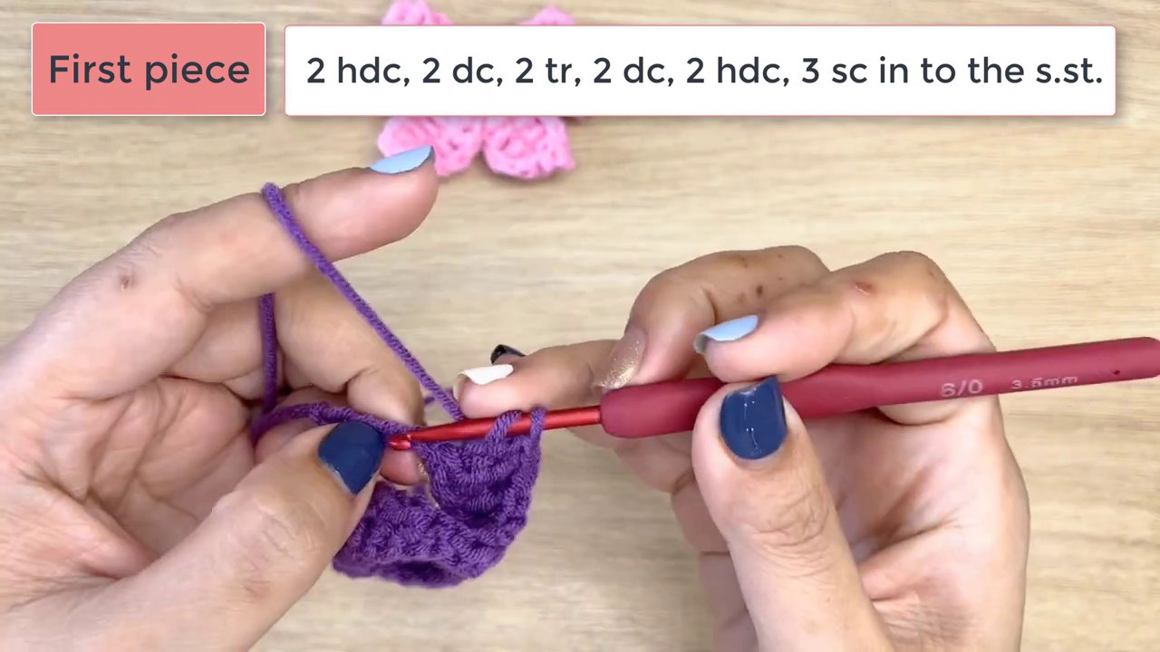 Master the Art of Crochet: A Step-by-Step Guide to Crafting a Beautiful Bow 7 The completed purple bow piece lies finished on the wooden surface, its loops and center band clearly formed.