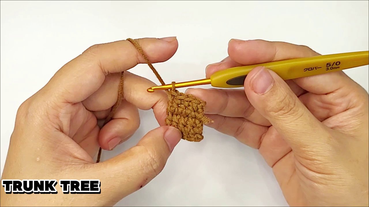 Craft a Festive Granny Square Christmas Tree: A Step-by-Step Crochet Tutorial 8 A potential assembly shot showing several completed granny squares arranged in a triangular tree shape next to the finished brown trunk, ready to be joined.